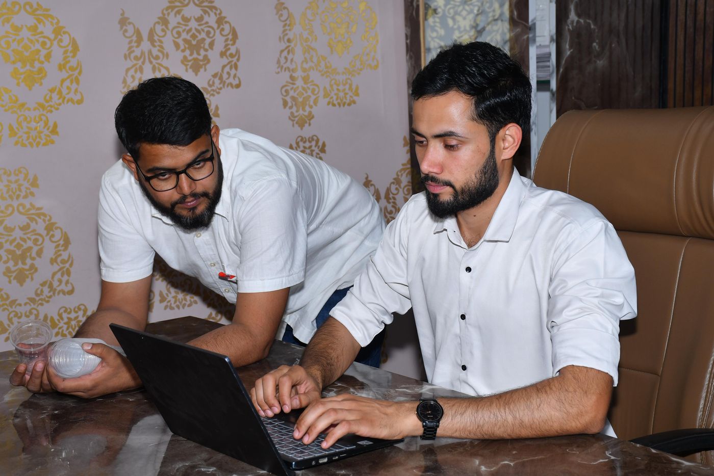 Illustrative photograph of professionals reviewing work together at a laptop